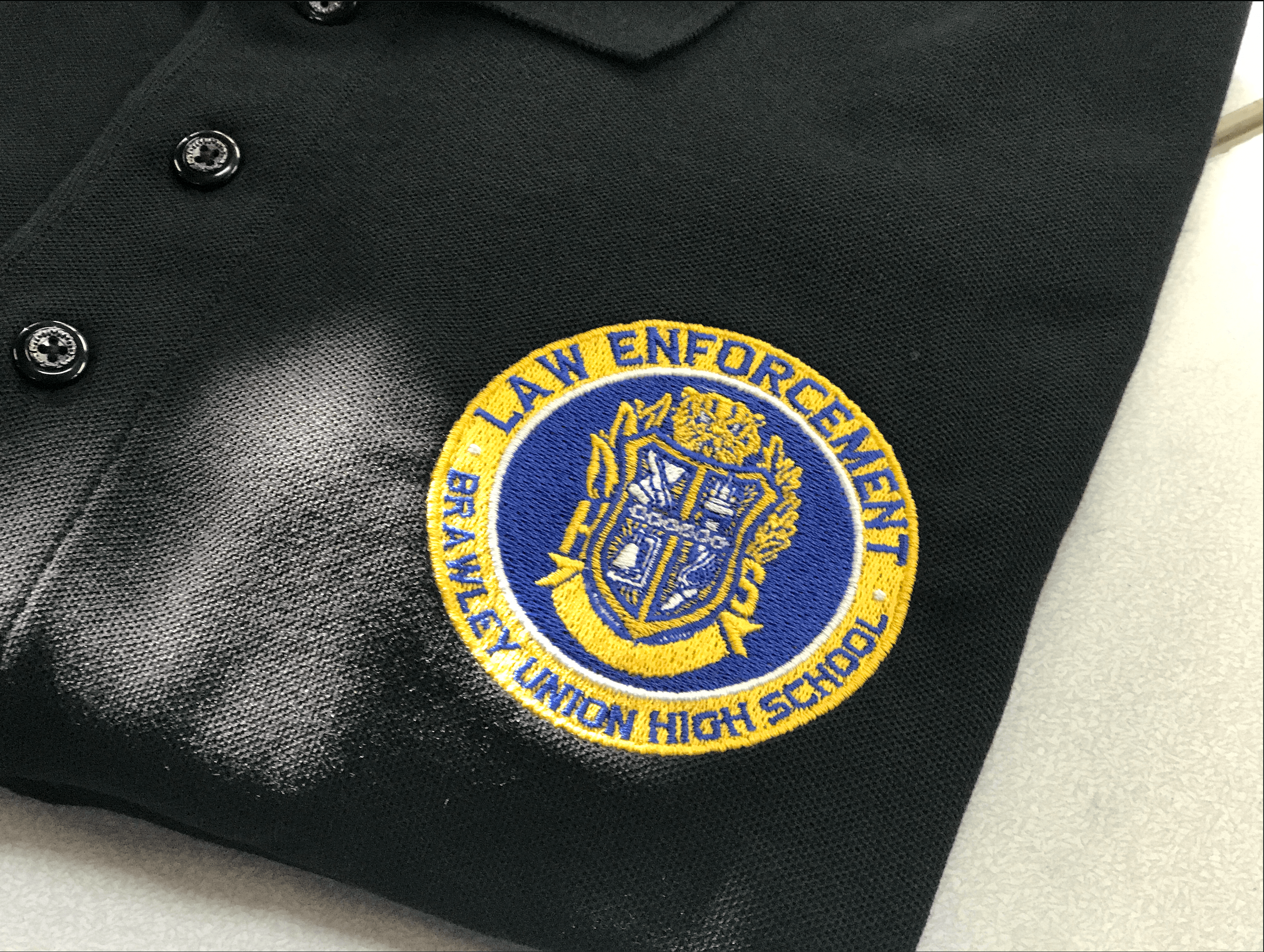 Close-up embroidered law enforcement patch and tactical apparel representing premium commercial embroidery